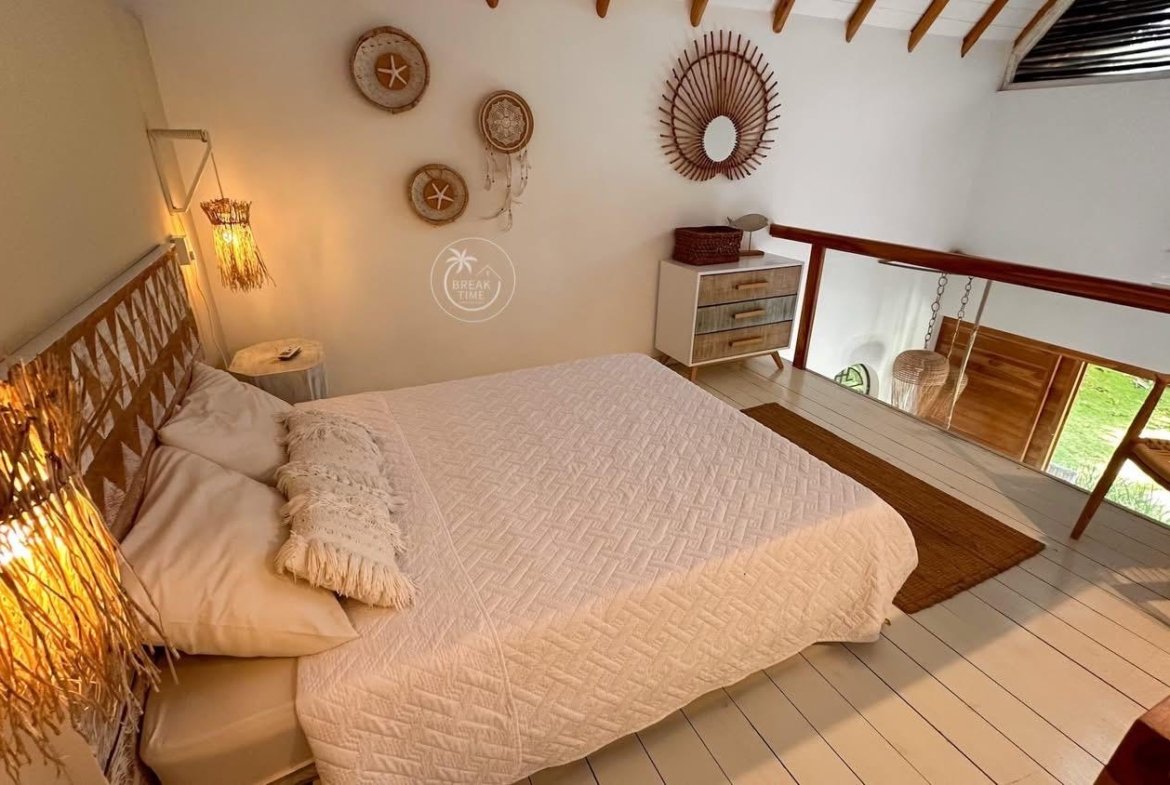 Dormitorio abuhardillado con cama doble y decoración natural