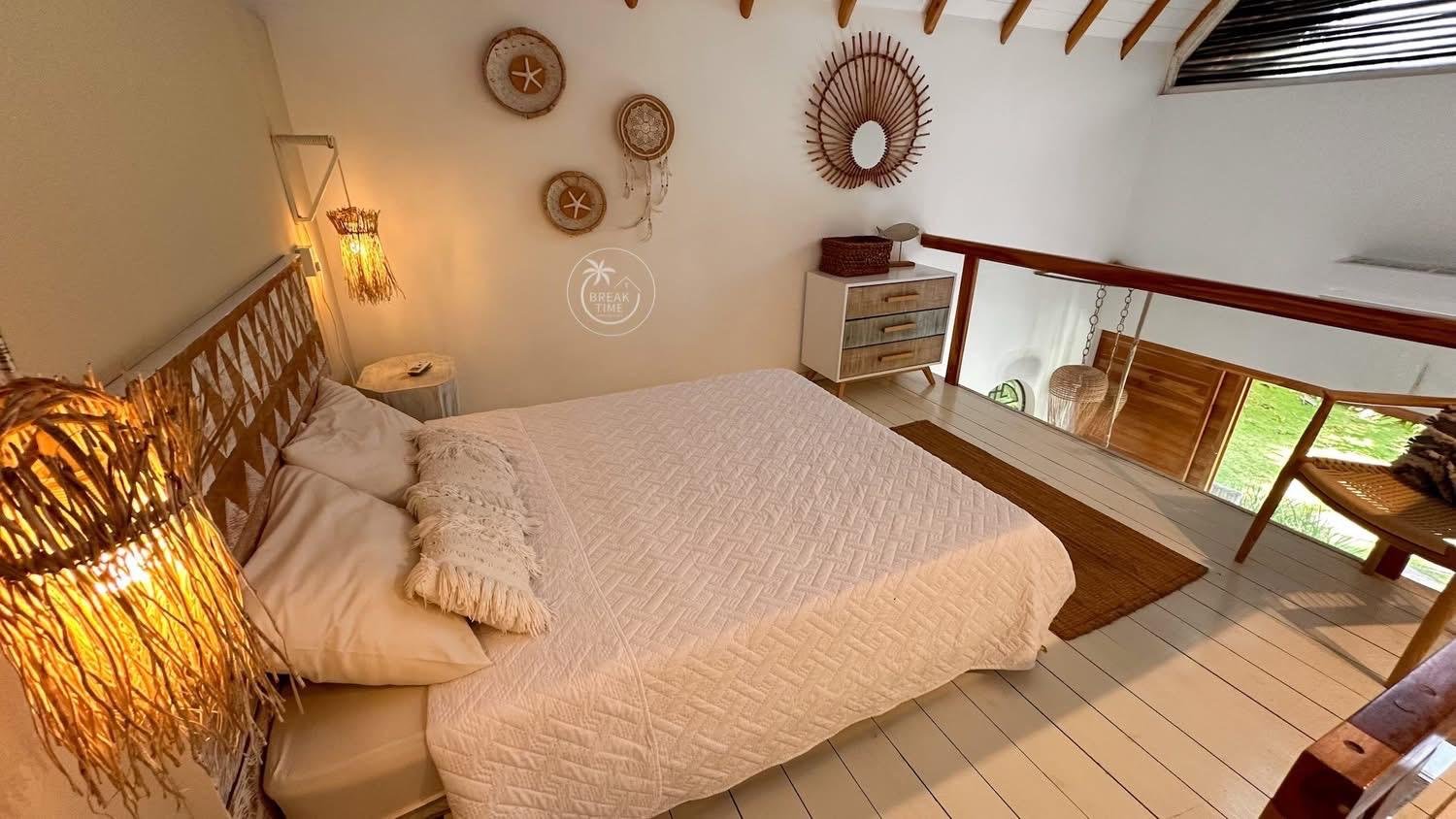 Dormitorio abuhardillado con cama doble y decoración natural