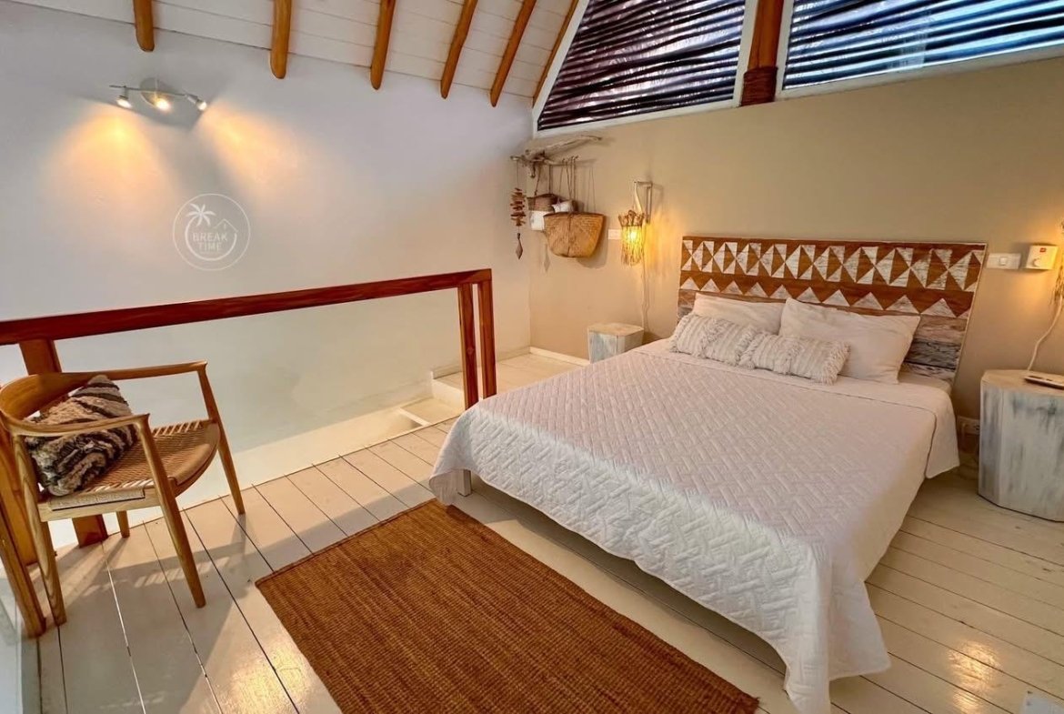 Dormitorio acogedor con cama blanca y techo abuhardillado