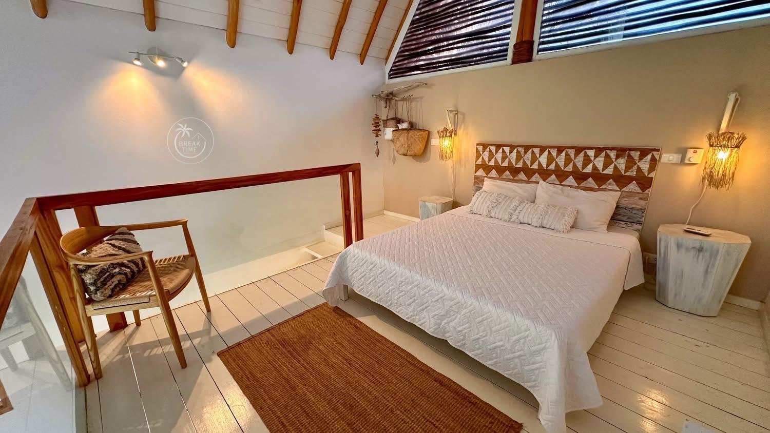 Dormitorio acogedor con cama blanca y techo abuhardillado