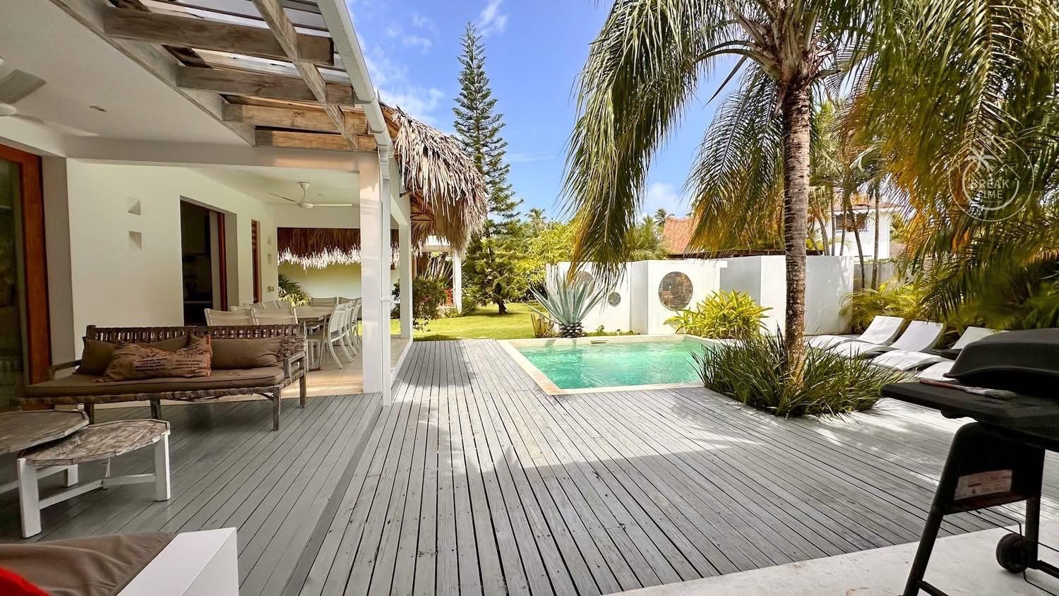 Terraza tropical con piscina y palmeras
