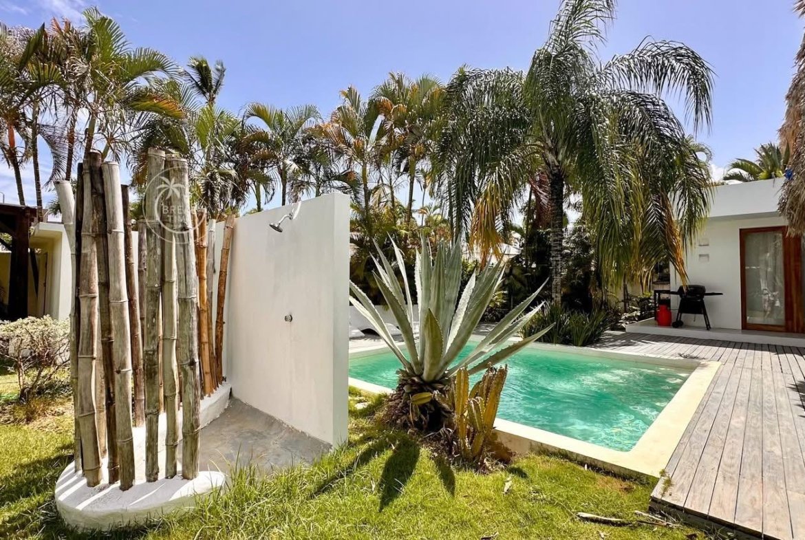 Piscina tropical con palmeras y ducha exterior