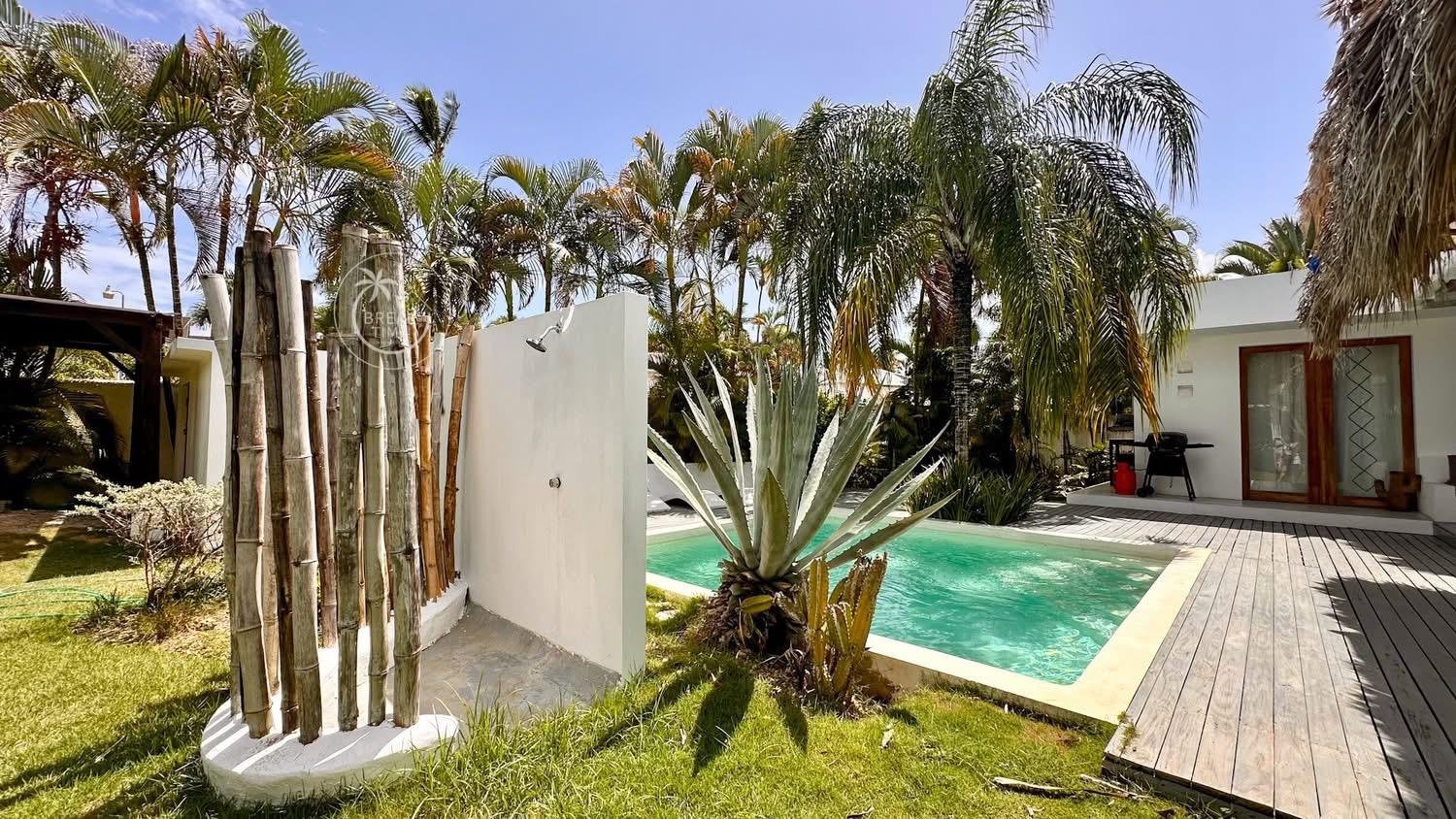 Piscina tropical con palmeras y ducha exterior