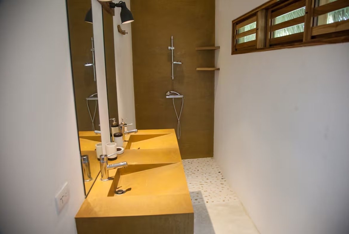 Baño moderno con lavabo doble y ducha