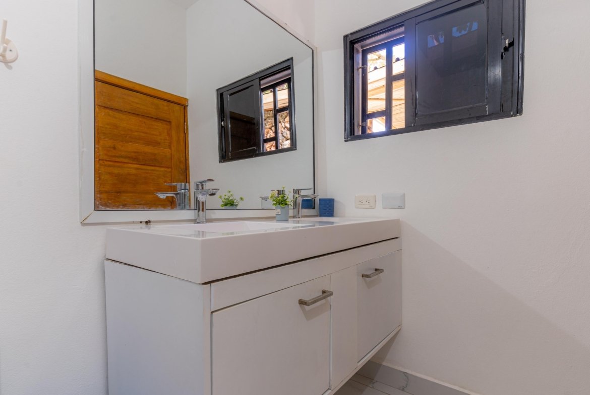 Baño moderno con lavabo y espejo grande