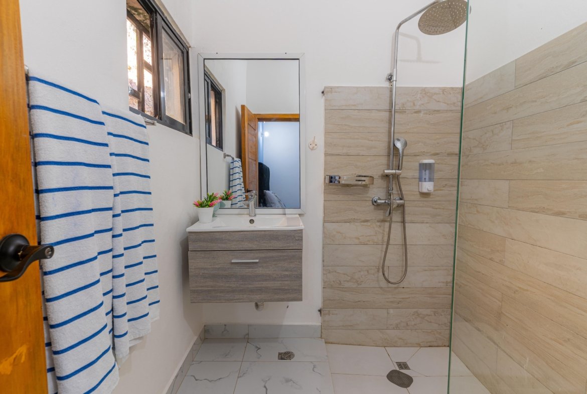 Baño moderno con ducha y lavabo suspendido