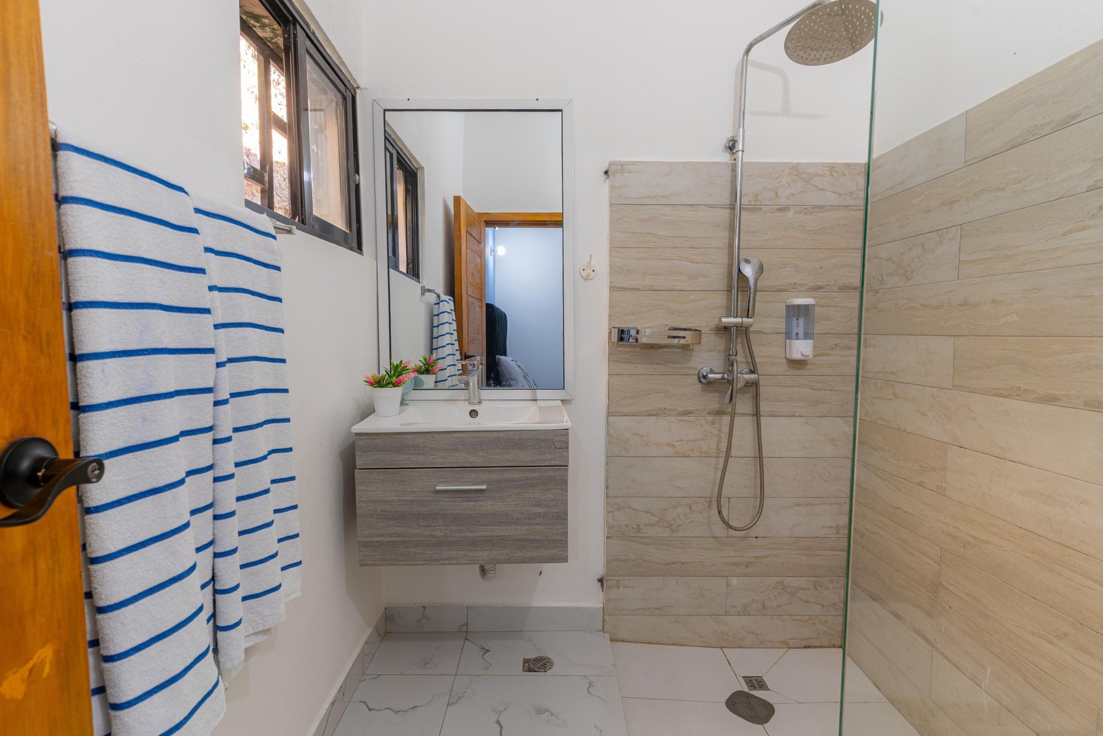 Baño moderno con ducha y lavabo suspendido