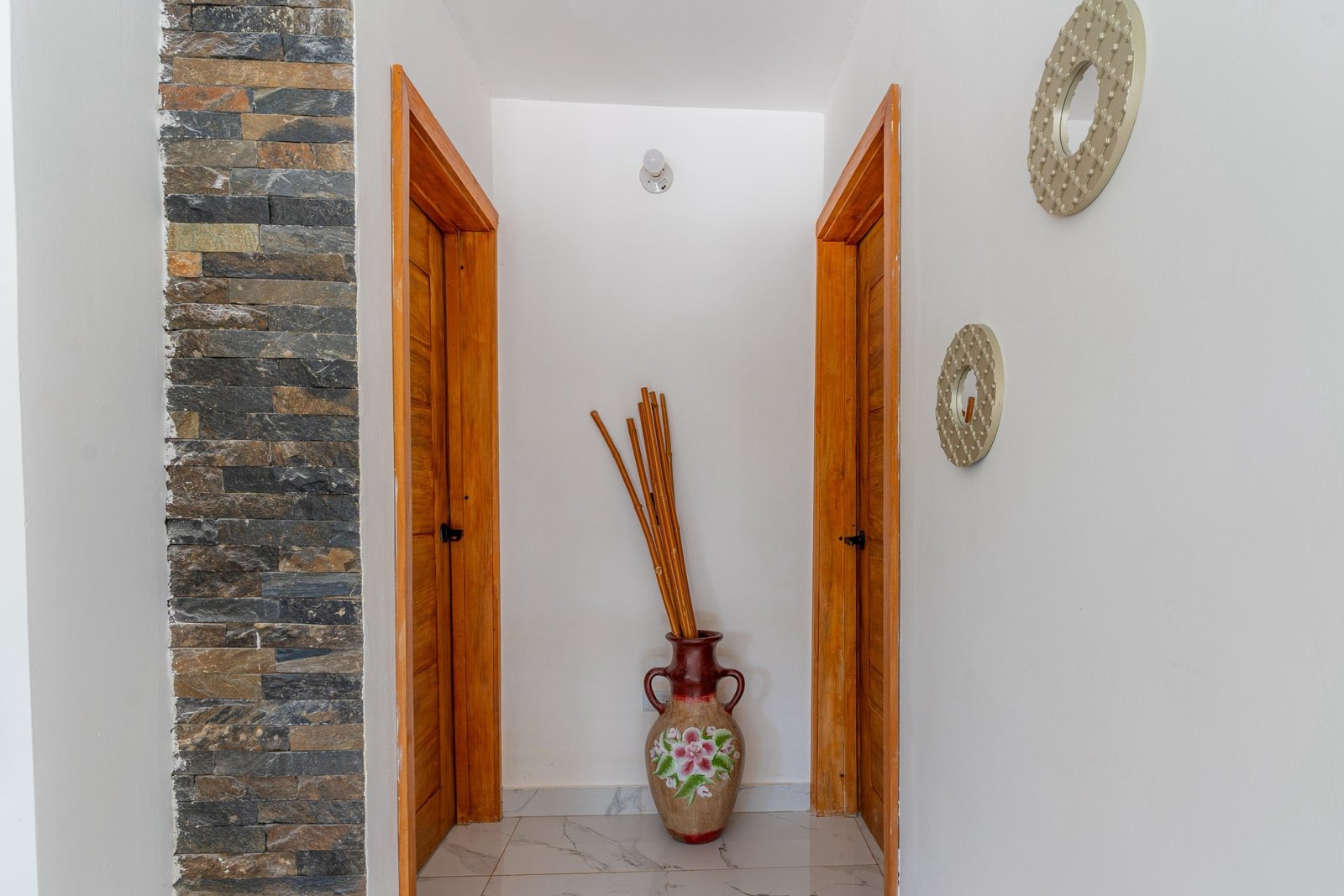 Pasillo con puertas de madera y jarrón decorativo