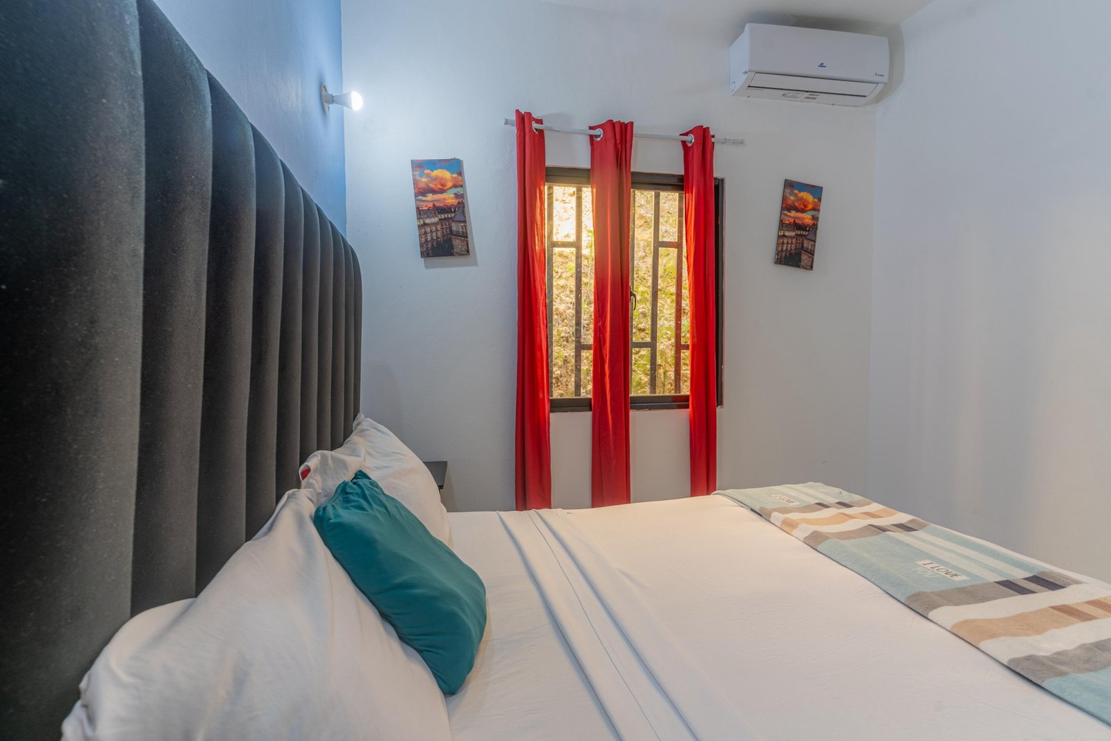 Dormitorio moderno con cama doble y cortinas rojas
