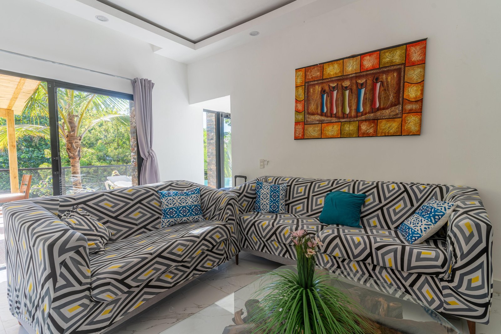 Salón moderno con sofás geométricos y terraza tropical