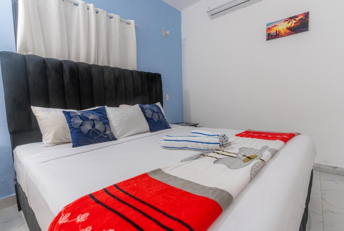 Dormitorio moderno con cama grande y cojines azules