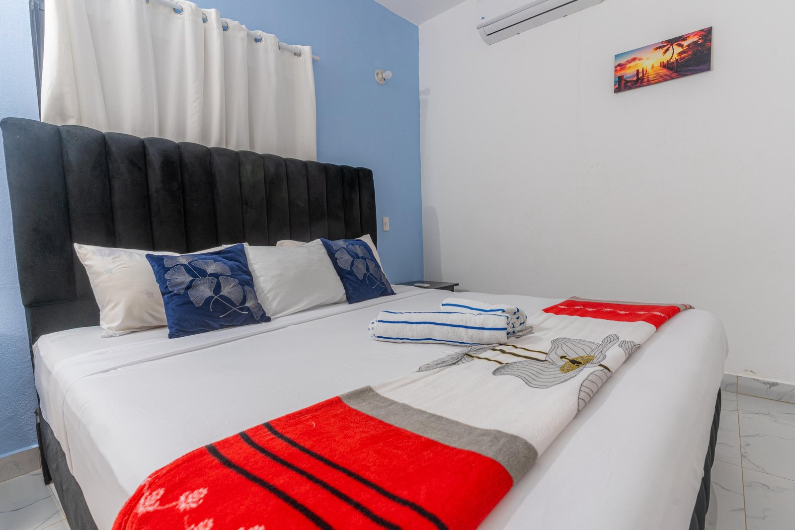 Dormitorio moderno con cama grande y cojines azules