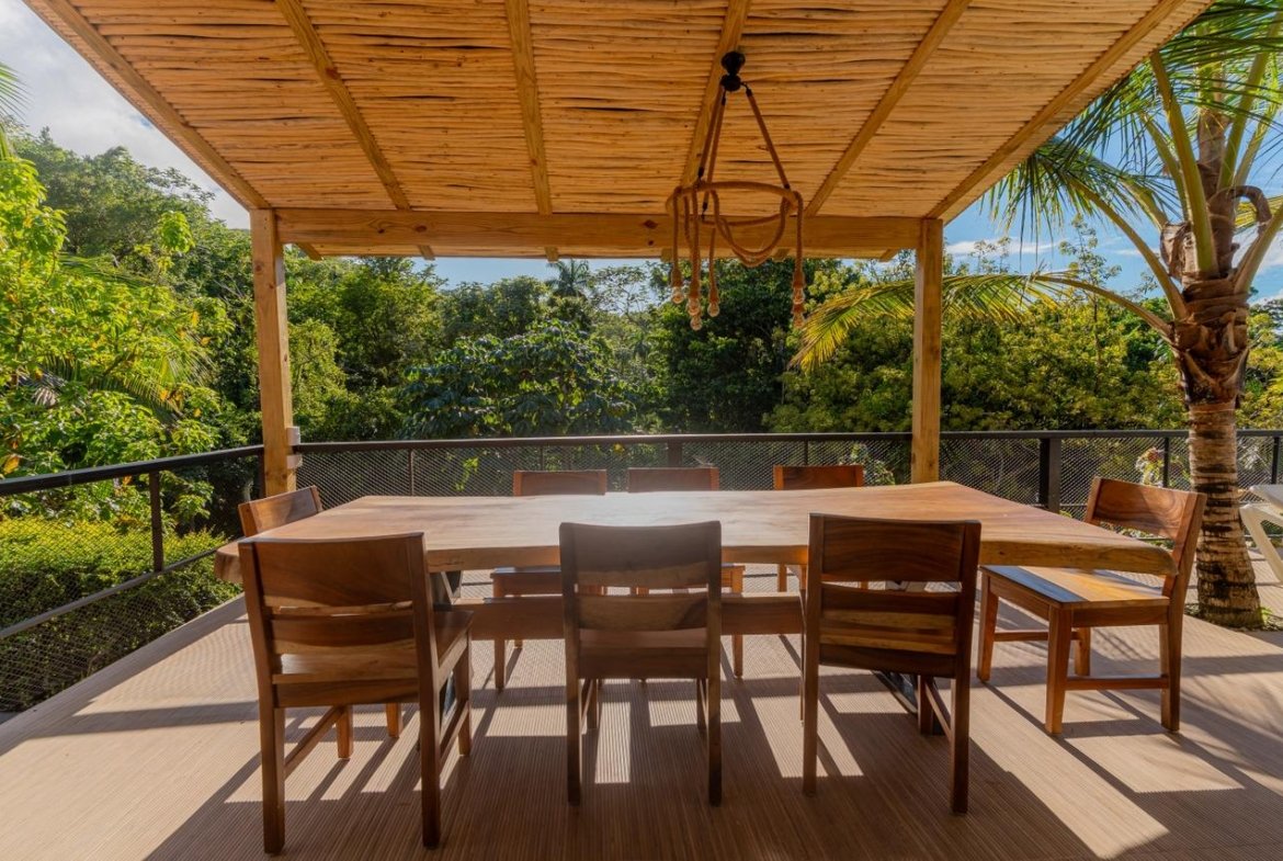 Terraza de madera con mesa y vistas tropicales