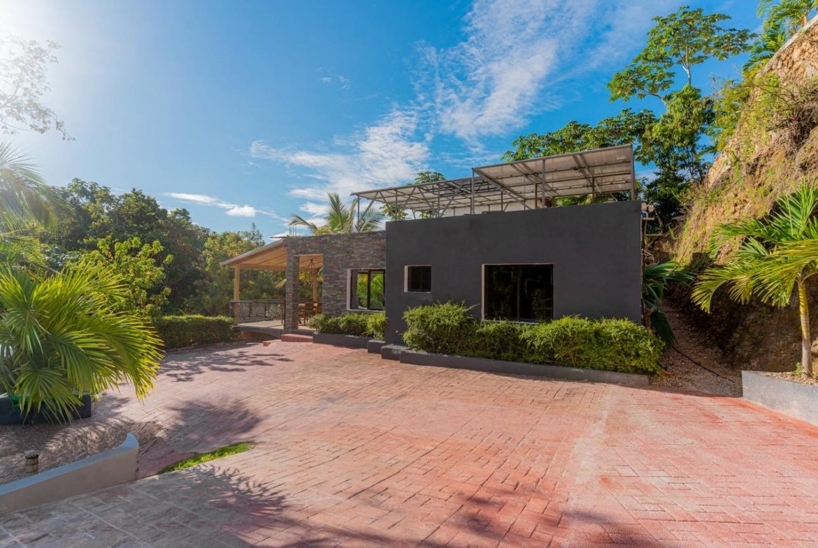Casa moderna con terraza y jardín tropical