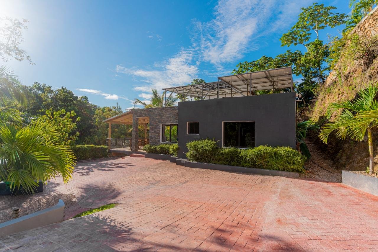 Casa moderna con terraza y jardín tropical