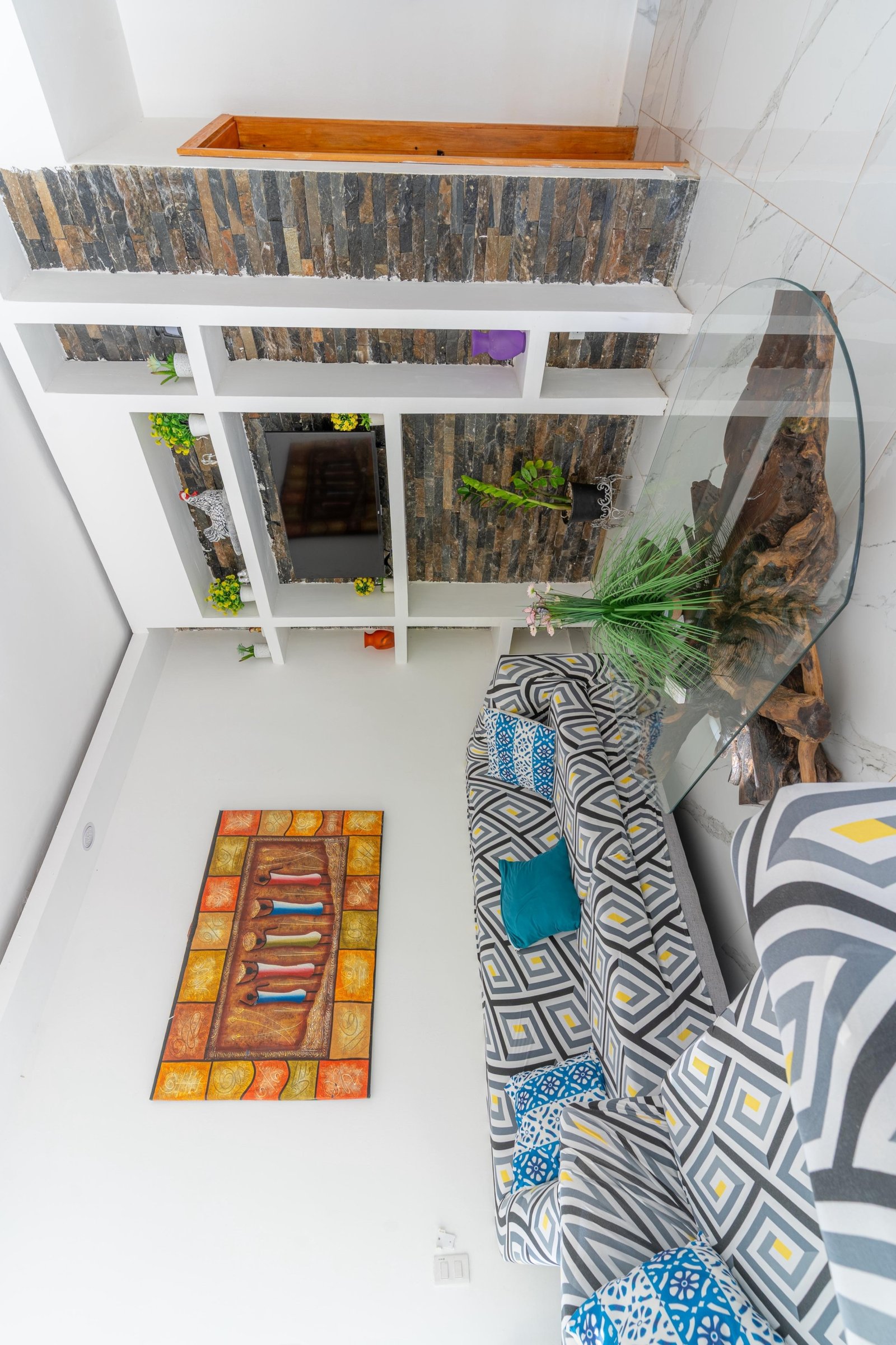 Salón moderno con sofá geométrico y pared de piedra