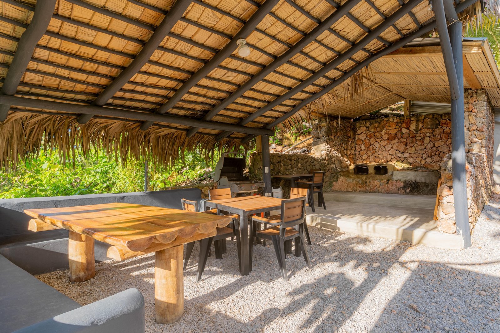 Porche rústico con mesas y barbacoa