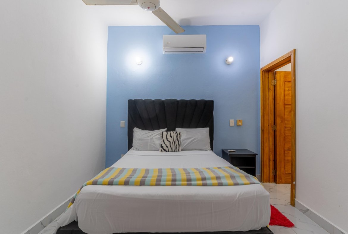 Dormitorio moderno con cama doble y pared azul