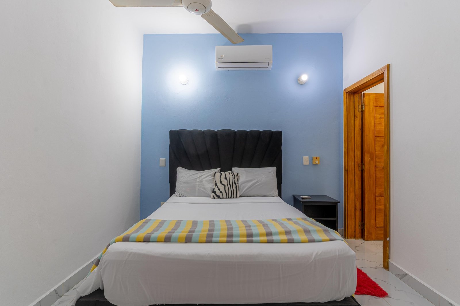 Dormitorio moderno con cama doble y pared azul