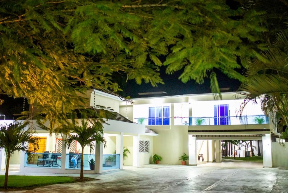 Casa moderna iluminada de noche con jardín