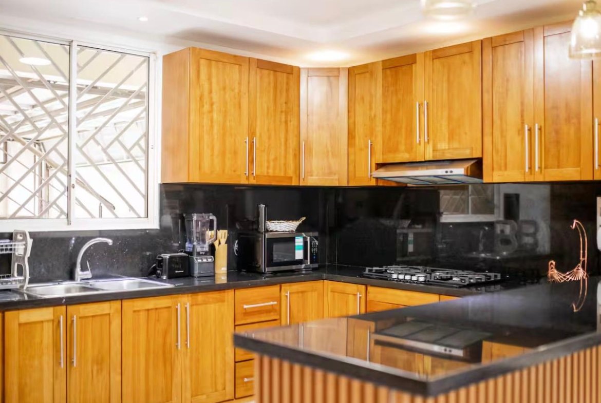 Cocina moderna con muebles de madera y encimera negra