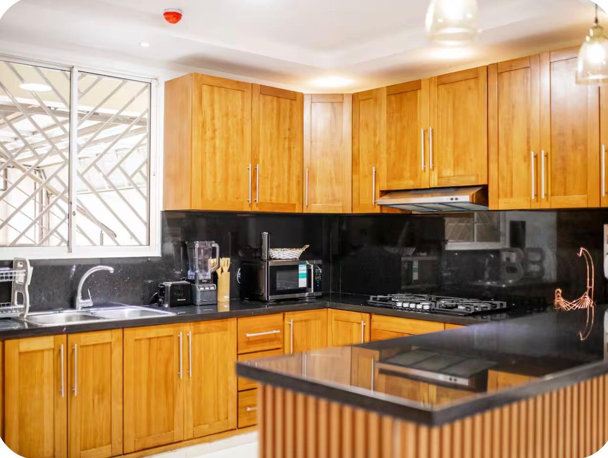 Cocina moderna con muebles de madera y encimera negra
