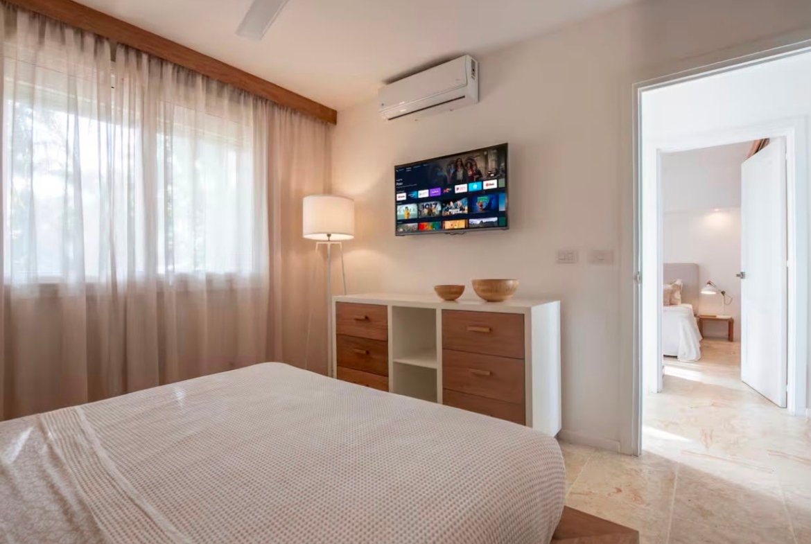 Dormitorio moderno con televisión y cómoda de madera