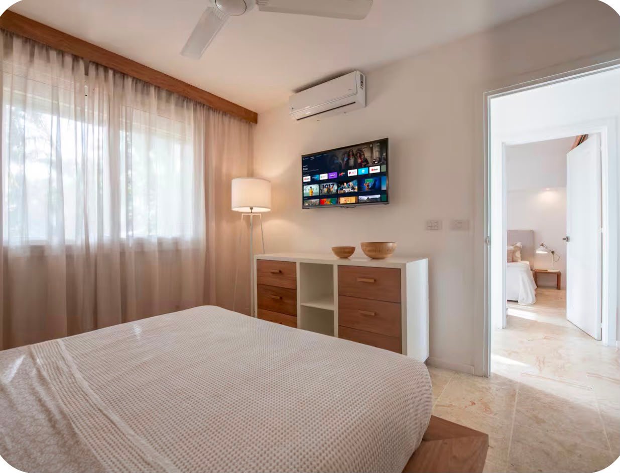 Apartamento A Popi (10) Dormitorio moderno con televisión y cómoda de madera