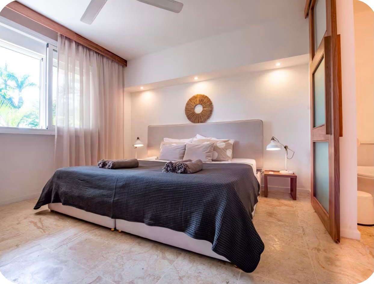 Apartamento A Popi (11) Dormitorio moderno con cama grande y decoración minimalista