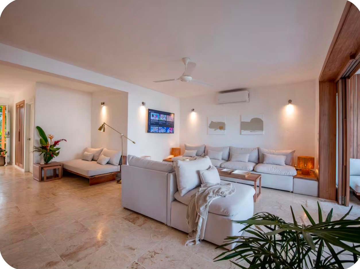 Apartamento A Popi (7) Salón moderno luminoso con sofás blancos y decoración minimalista