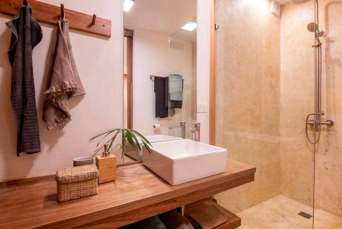 Baño moderno con ducha y lavabo sobre encimera