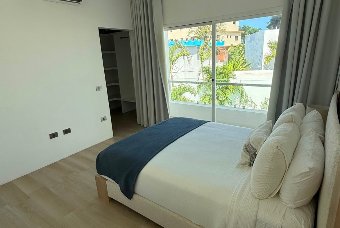 Dormitorio moderno con cama y gran ventana