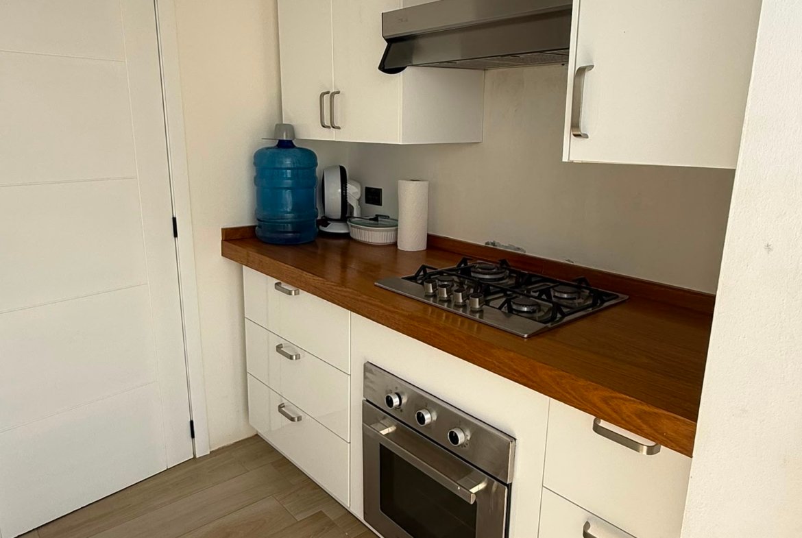 Cocina moderna blanca con encimera de madera