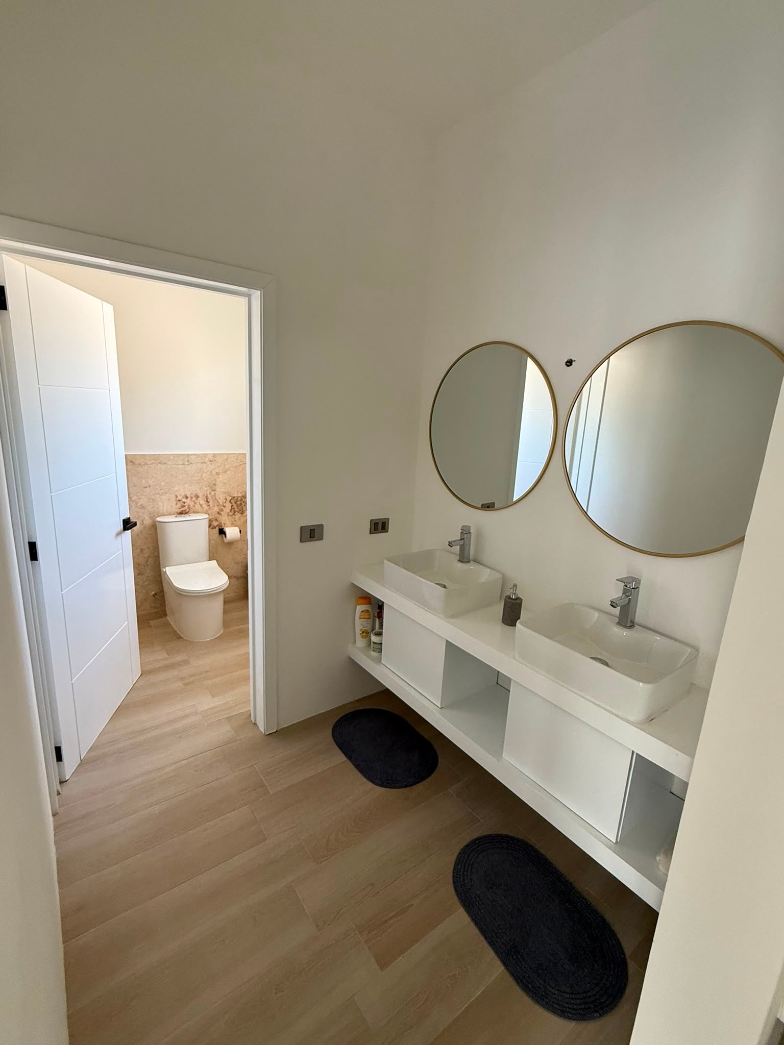 Villa En La Ceiba (12) Baño moderno con doble lavabo y espejos redondos