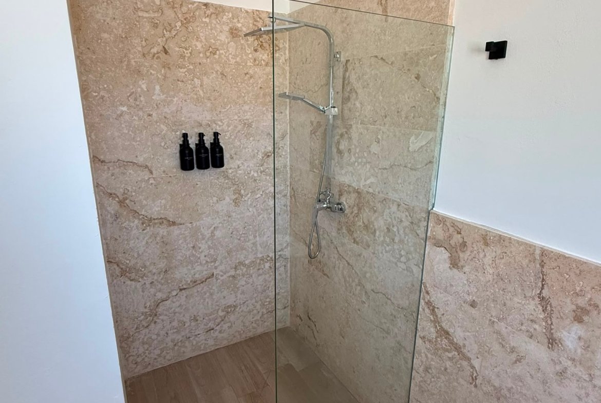 Ducha moderna con mampara de cristal y mármol
