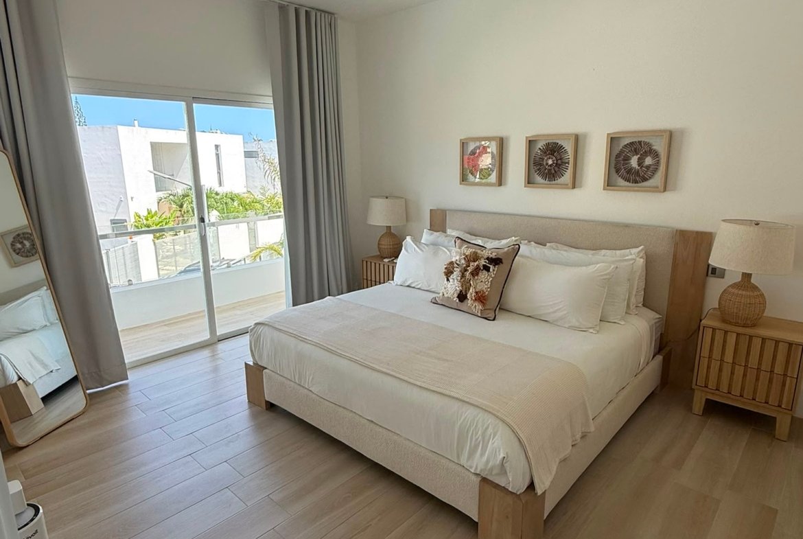 Dormitorio moderno luminoso con cama y ventilador de techo