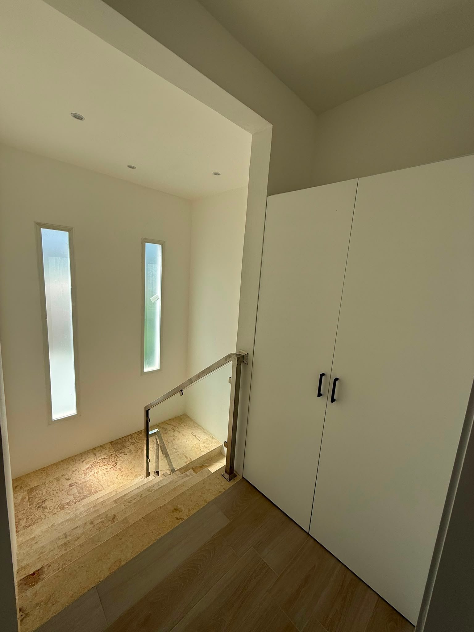 Villa En La Ceiba (9) Escalera moderna con ventanales estrechos y armario blanco