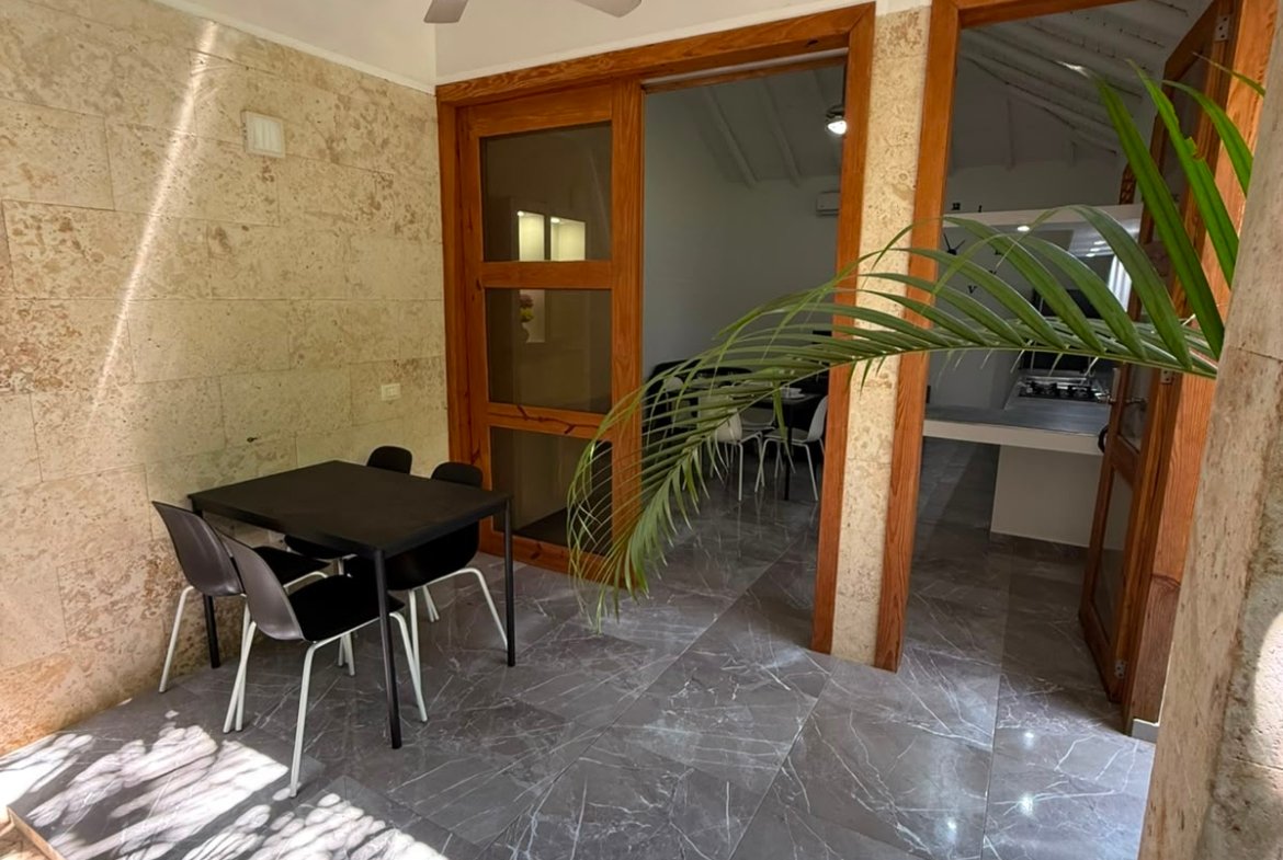 Terraza cubierta con mesa y sillas modernas
