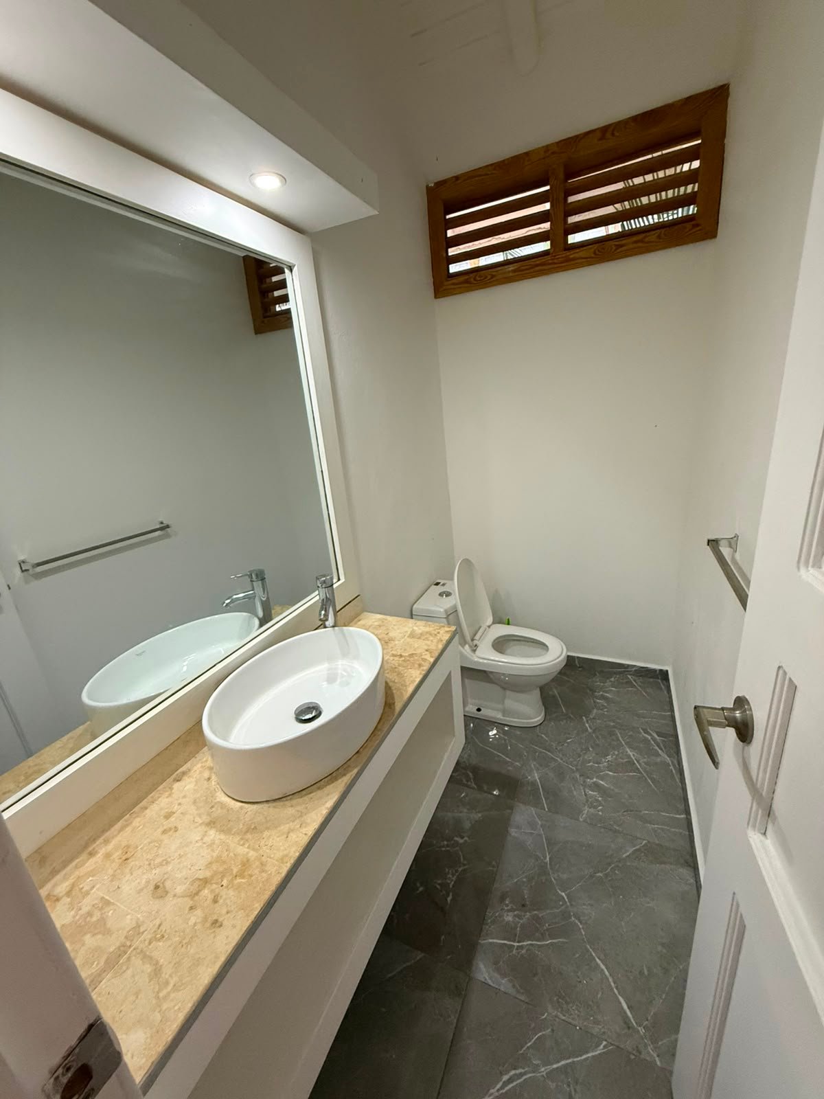 Baño moderno pequeño con lavabo y espejo grande