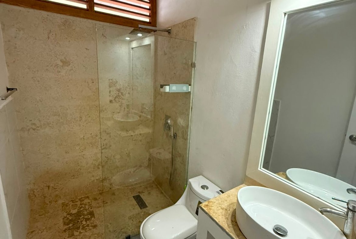 Baño moderno con ducha de cristal y lavabo