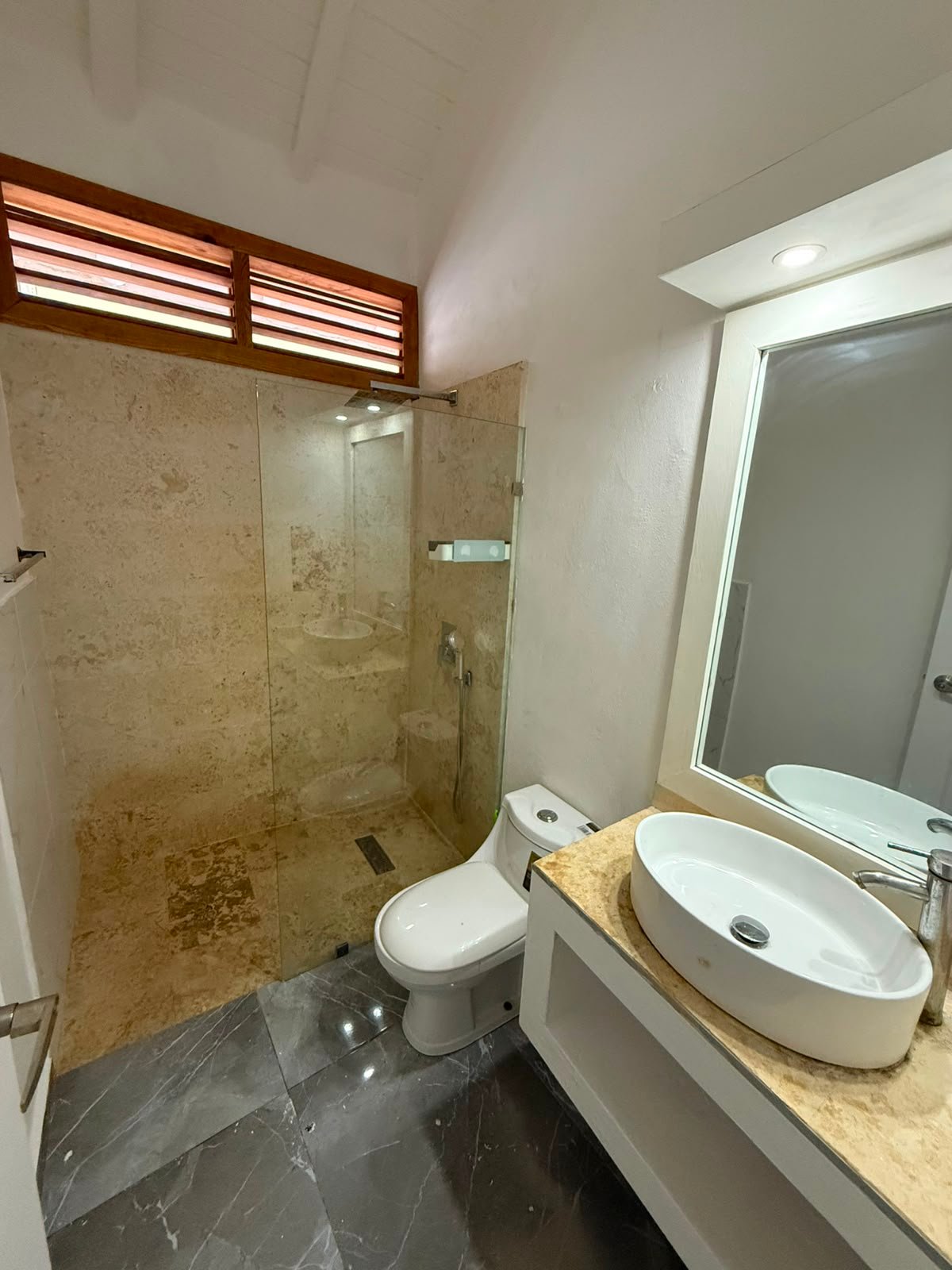 Baño moderno con ducha de cristal y lavabo