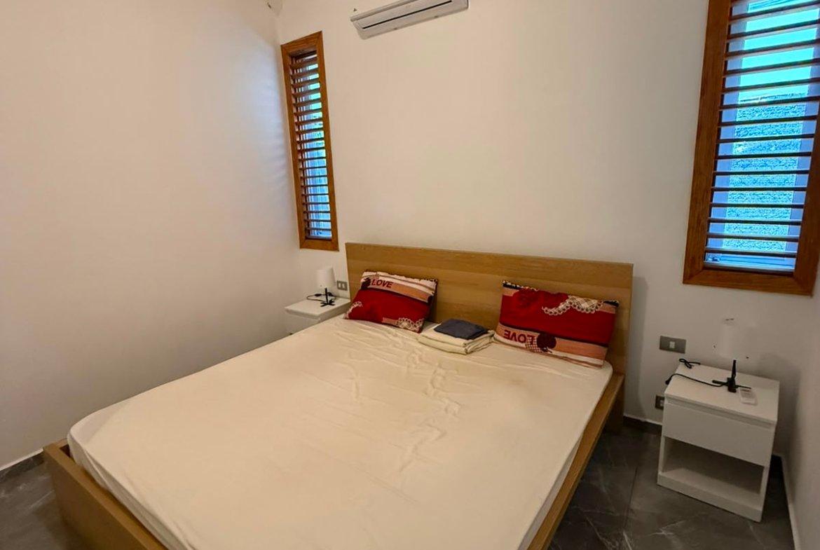 Dormitorio moderno con cama doble y techo abuhardillado