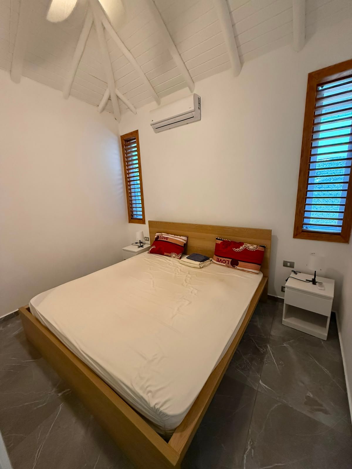 Dormitorio moderno con cama doble y techo abuhardillado