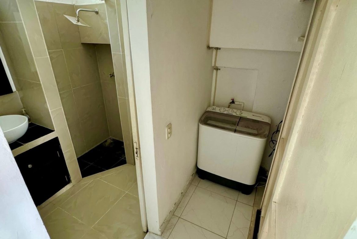 Lavadora junto a baño con ducha pequeña