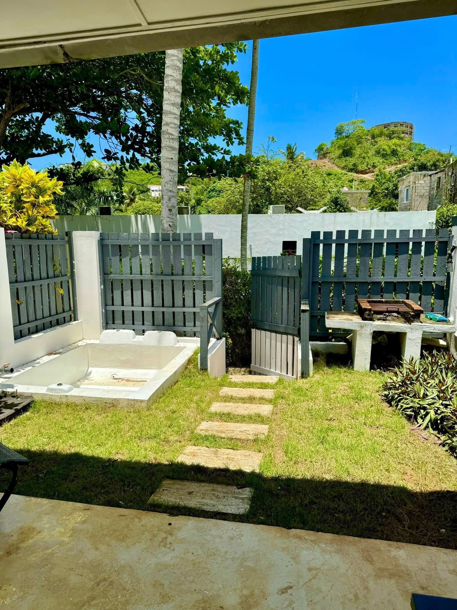 Casita Dentro Una Residencia (8) Jardín soleado con valla gris y barbacoa