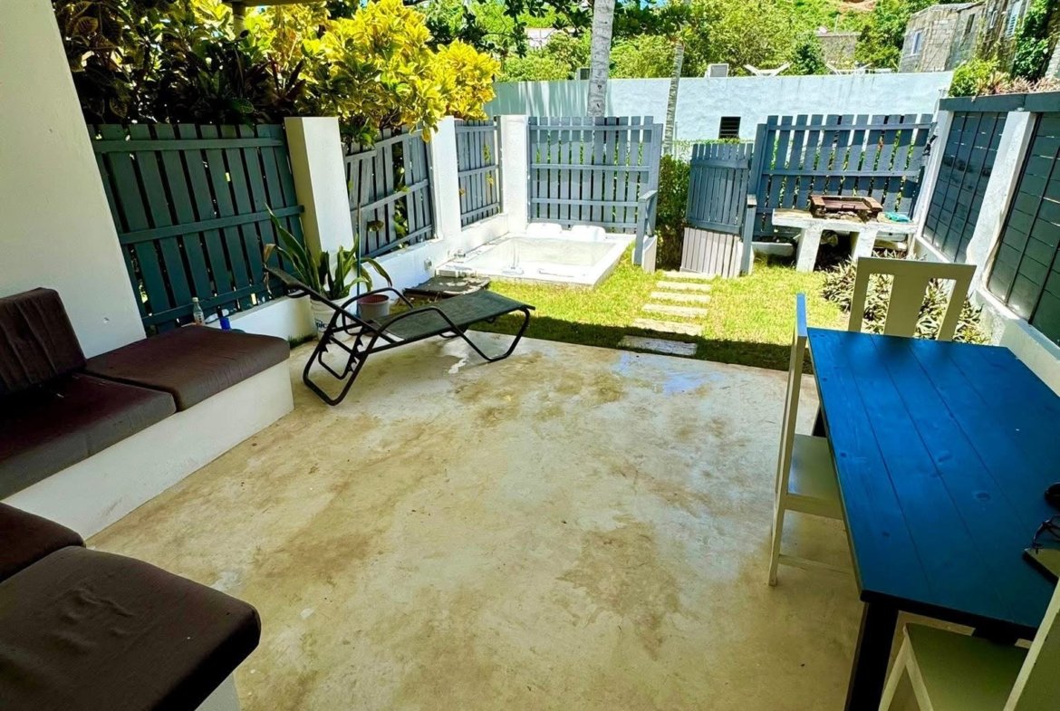 Patio cubierto con jardín y tumbona