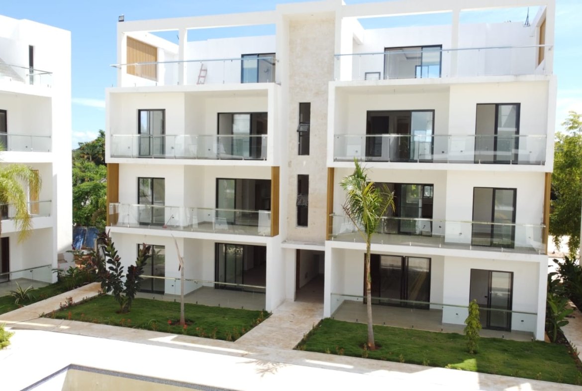 Edificio residencial moderno con balcones de cristal y jardines