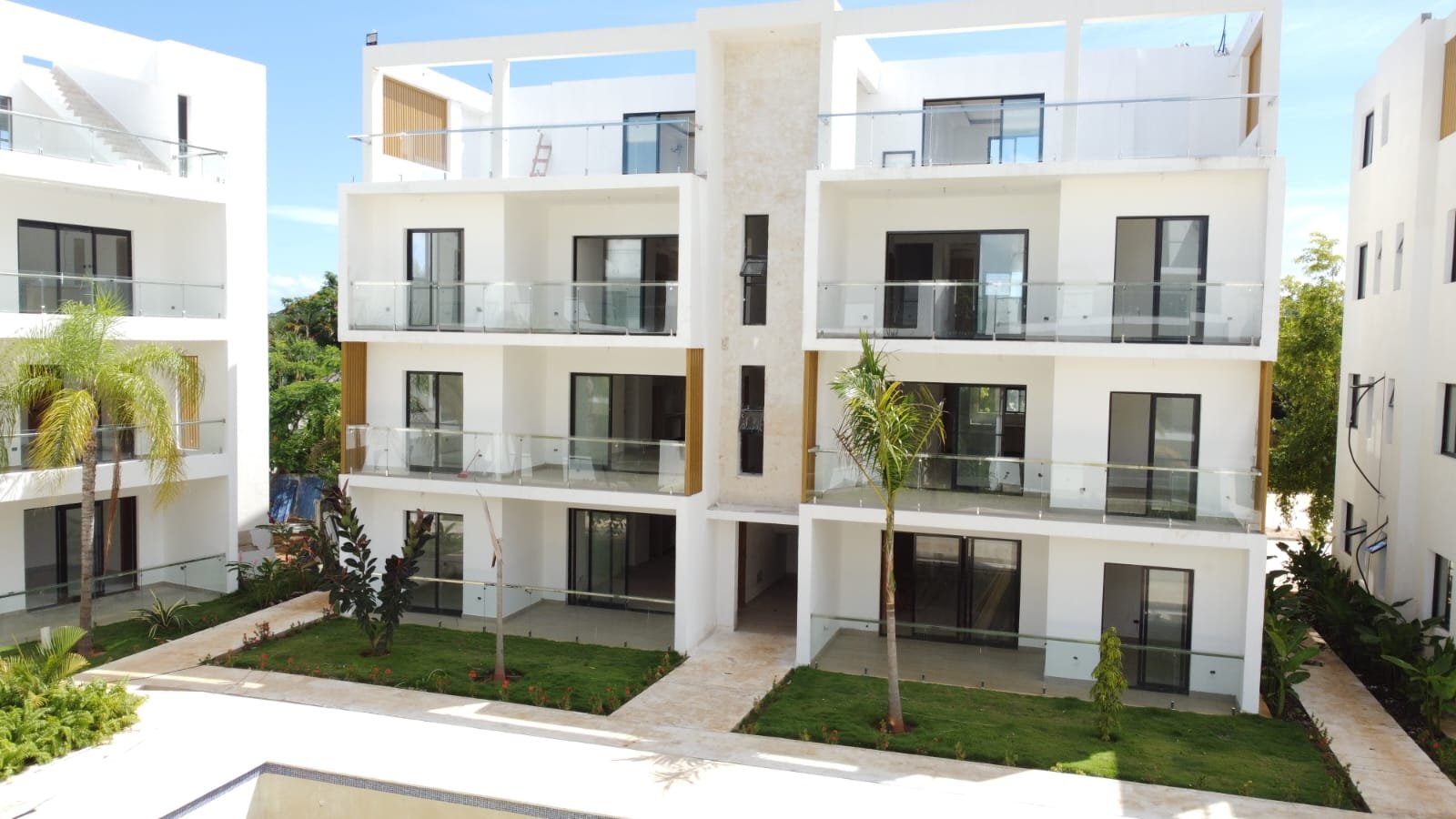 Edificio residencial moderno con balcones de cristal y jardines