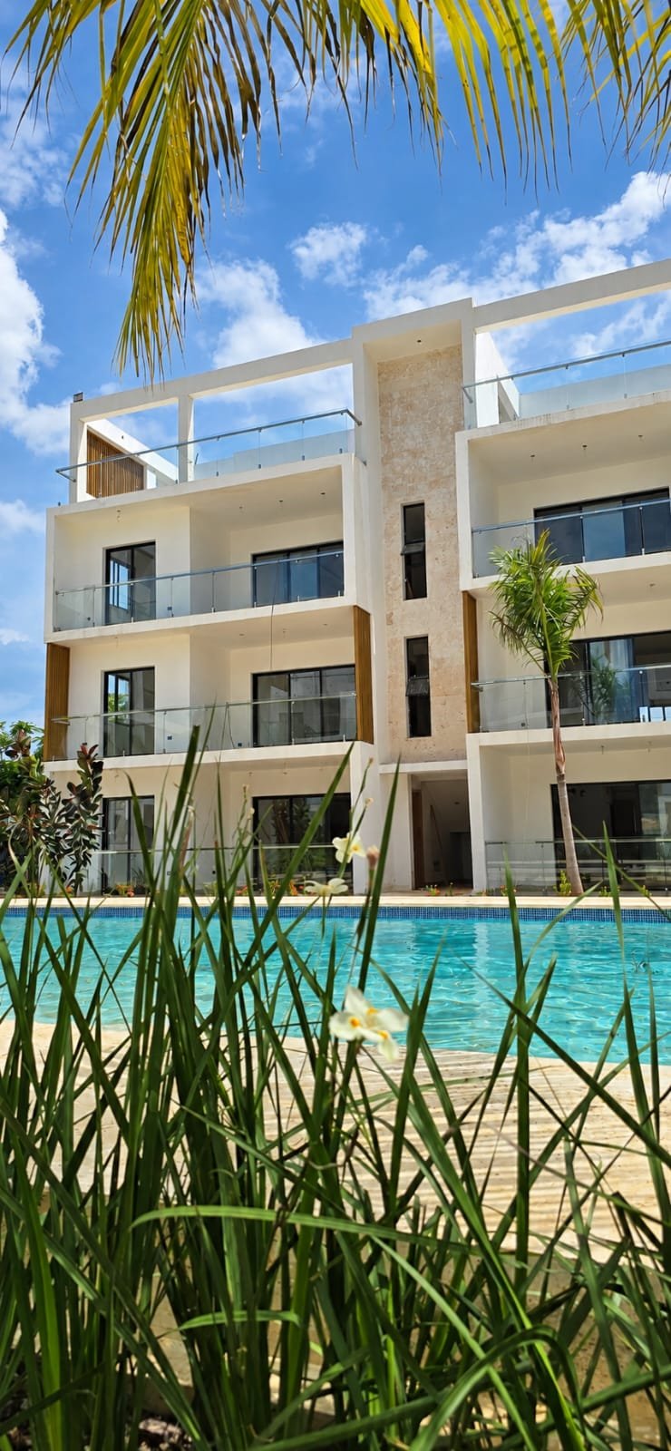 Edificio moderno con piscina y palmeras tropicales