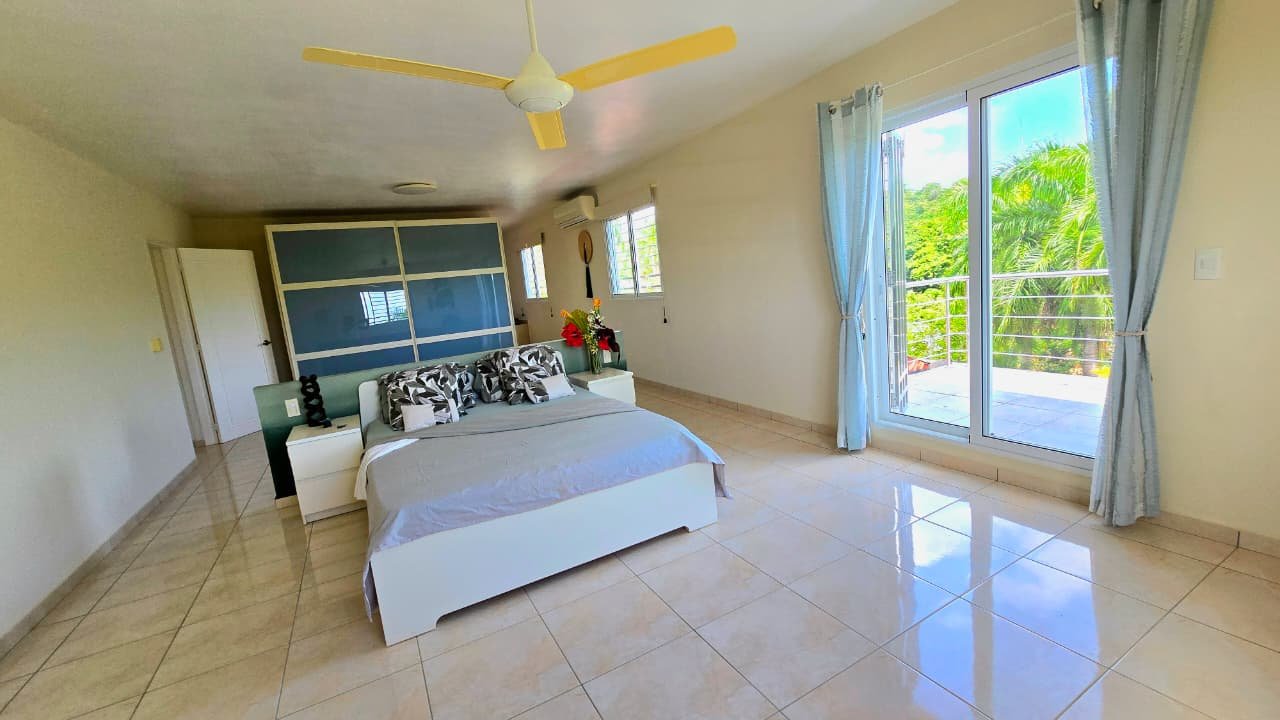 Villa en el limon (10) Dormitorio luminoso con cama doble y acceso a terraza